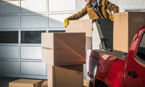 Man putting cardboard boxes on a red truck bed